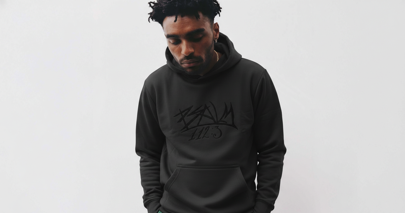 Man wearing a black hoodie with text on a white background